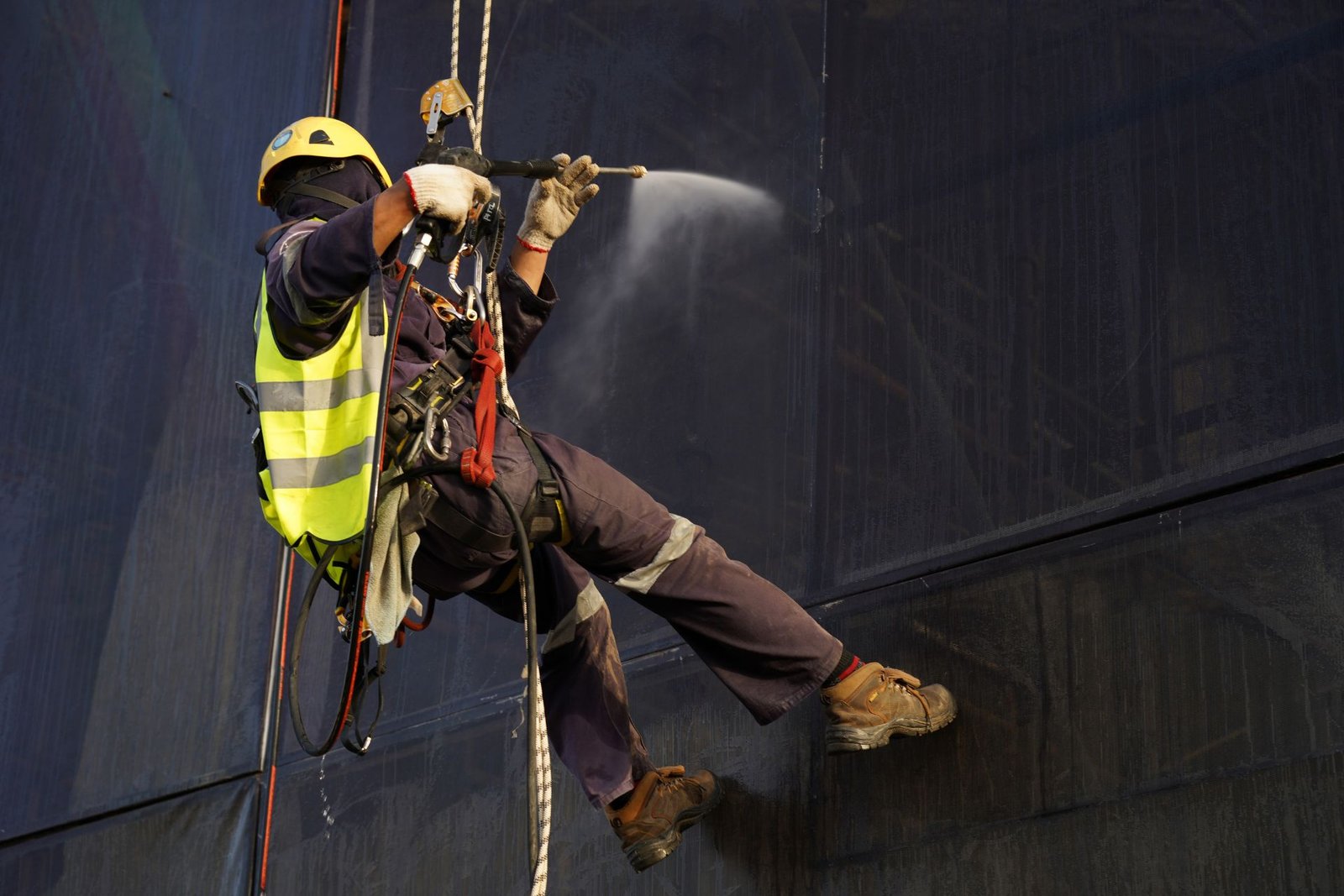 Rescue Professionals Conducting A Rope Access Rescue Operation Using Harnesses, Ropes, And Safety Equipment To Reach And Assist A Suspended Worker.