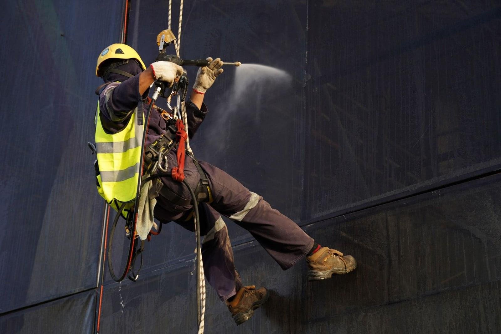 Rescue Professionals Conducting A Rope Access Rescue Operation Using Harnesses, Ropes, And Safety Equipment To Reach And Assist A Suspended Worker.